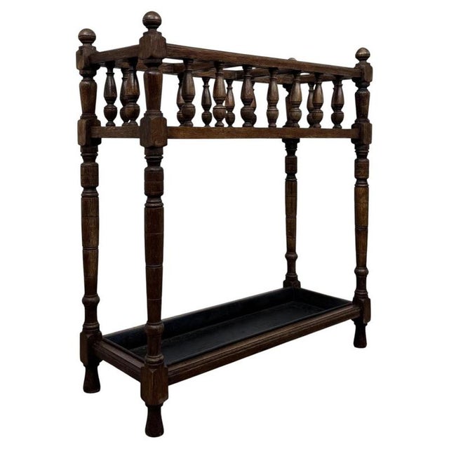 A beautifully crafted early 20th-century English Edwardian umbrella and stick stand, finely constructed in oak and...