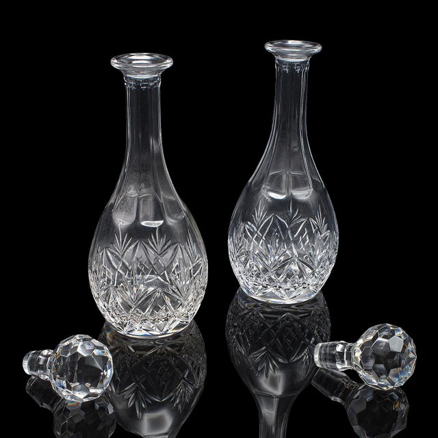 This is a pair of vintage spirit decanters. An English, cut glass liqueur bottle, dating to the late 20th century, circa...
