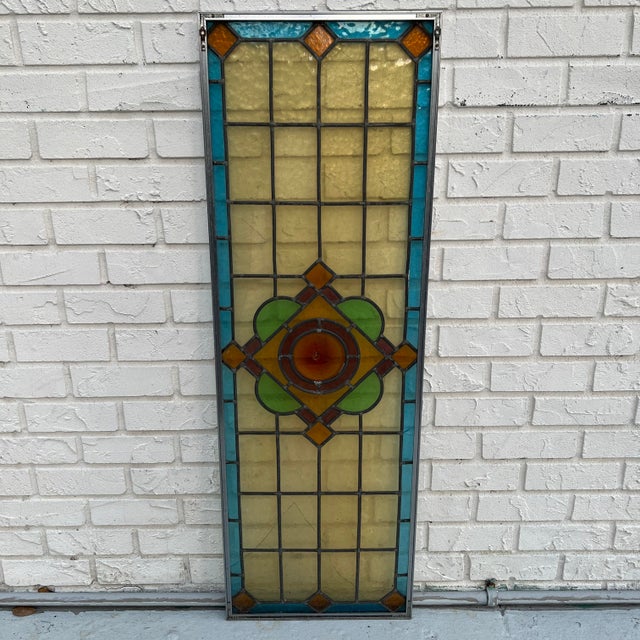 Antique architectural stained glass window panel in the Arts & Crafts style, centered by a striking amber eye bullseye...