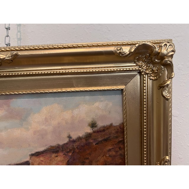 This original vintage oil painting depicts a quiet rural landscape with rolling terrain, earthy paths, and distant...