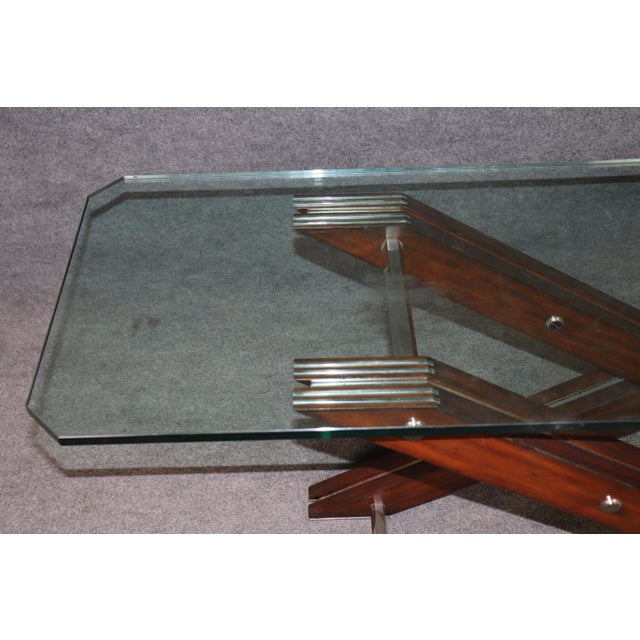 A striking and architecturally inspired modern console table, masterfully designed with a dramatic intersecting X-form...