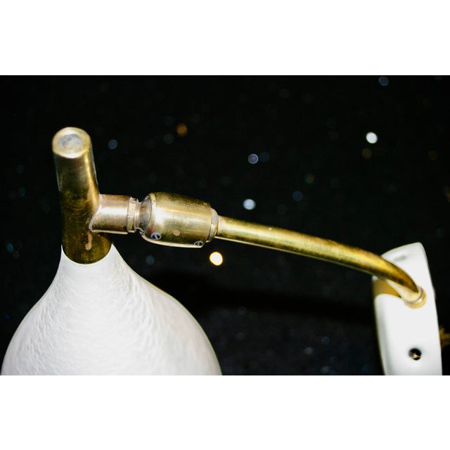 Wall sconce with a finely crafted, adjustable lampshade extended by a small brass dome, beige textured paint, in good...