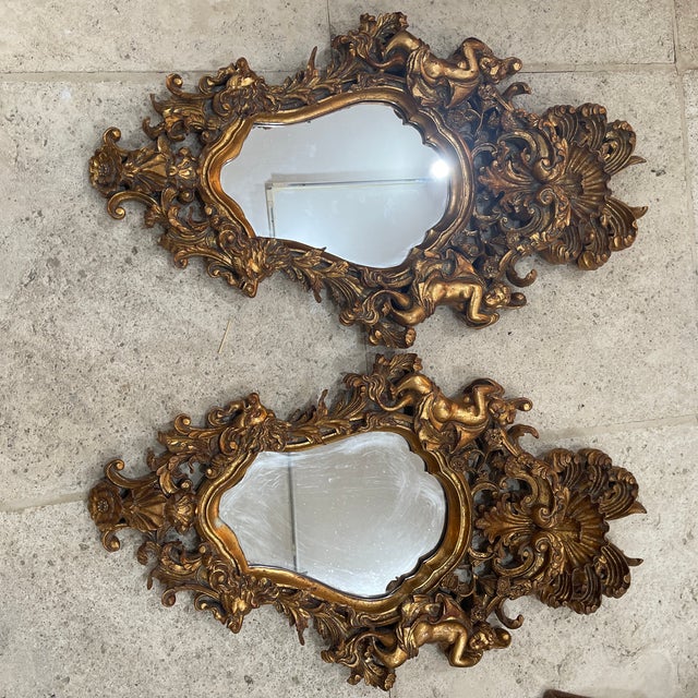 Two mirrored mirrors, each mounted in a composite frame crafted as foliage accented by lion's heads and puttos. CIRCA:...