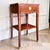 An elegant Federal-style mahogany nightstand featuring rich wood grain, refined lines, and custom gold-dipped feet. A...