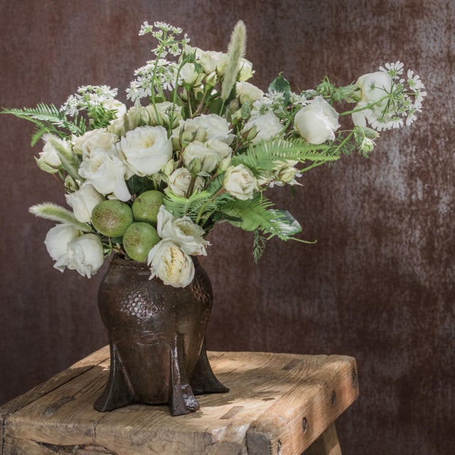 This vintage iron mortar from China's Shanxi province was cast in low relief with a delicate chrysanthemum in bloom....