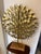 This is a a brutalist-style, multi-layered metal starburst art piece featuring interlocking gold-finished geometric metal...