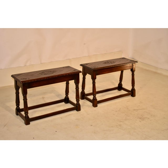 Pair of late 19th century oak benches from England . The benches have beveled and carved edges around the tops with carved...