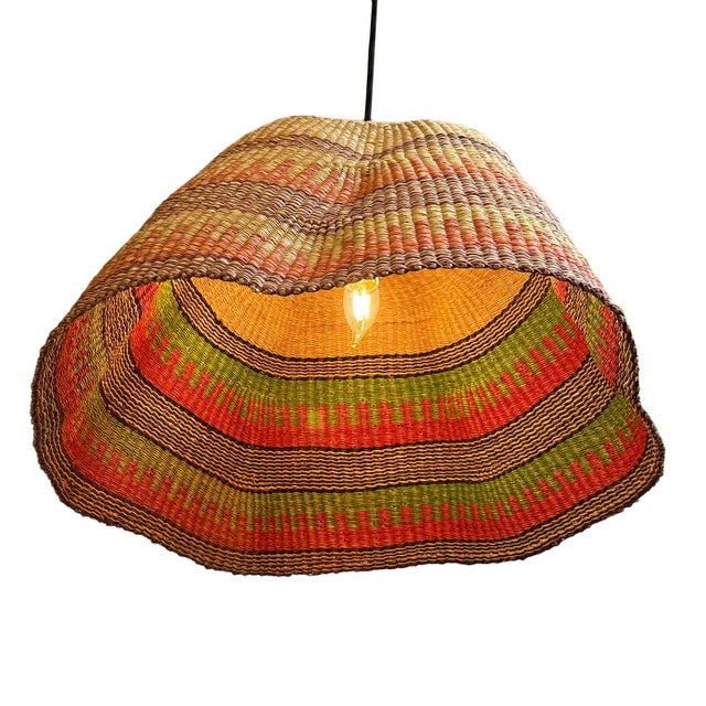 This pendant light began as a traditional Bolga basket from northern Ghana. These baskets were objects of daily use, woven...