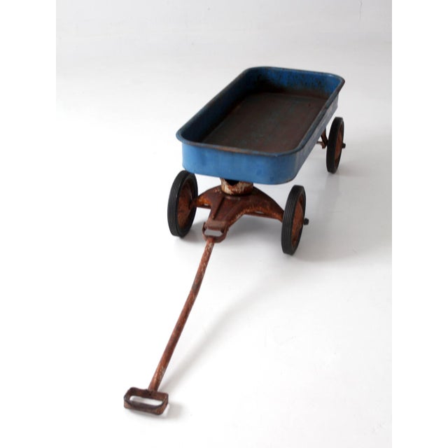 This vintage 1970s Radio Flyer Model 100 metal wagon features a wonderfully weathered blue finish and striking, crisp...