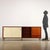 Sideboard with sliding doors, one hinged door, and open drawers in teak veneer and Formica with enameled metal legs. This...
