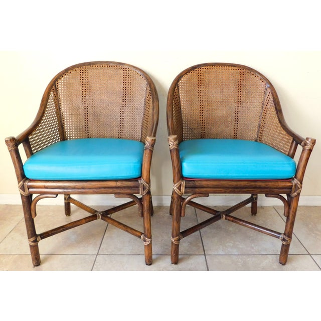 Fabulous pair of McGuire rattan and cane club chairs. Beautiful well-made chairs with leather straps. Aqua blue leather or...