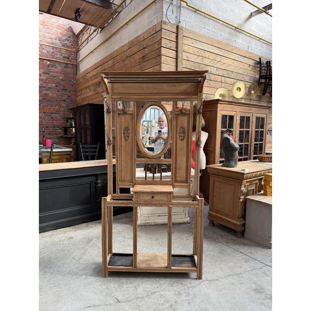This oak entryway coat rack has been fully restored. It comprises a hat rack, six hooks, a large oval beveled mirror, a...