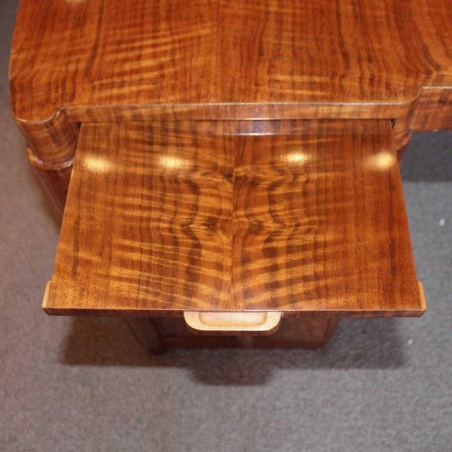 An art deco desk with curved corners by heal's of london. Drawers either side with integral sliding trays to top. Original...