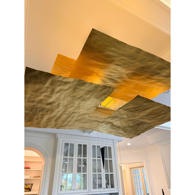 This beautiful pendant hangs with 6 sails of Japanese paper covered in gold leaf. The light flows from the top down...