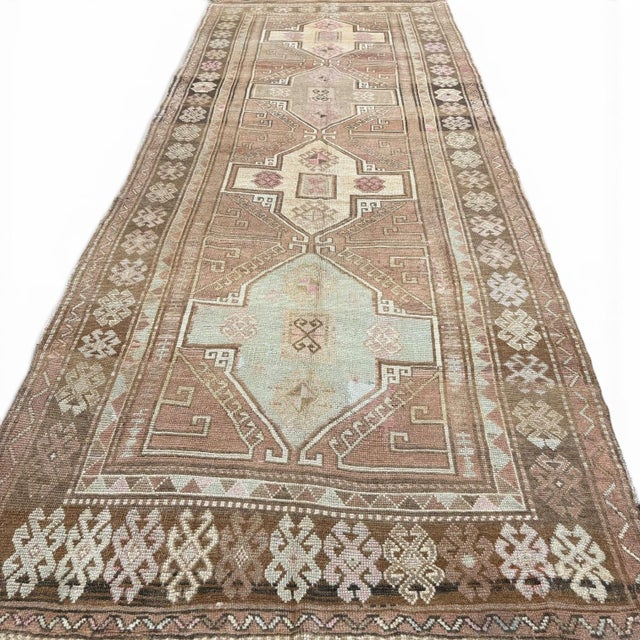 This elegant vintage runner from Kars, Turkey, showcases the bold geometric tradition of Anatolian weaving with a refined...