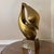This is a striking abstract bronze sculpture featuring smooth, flowing curves and an elegant organic form. The piece has a...