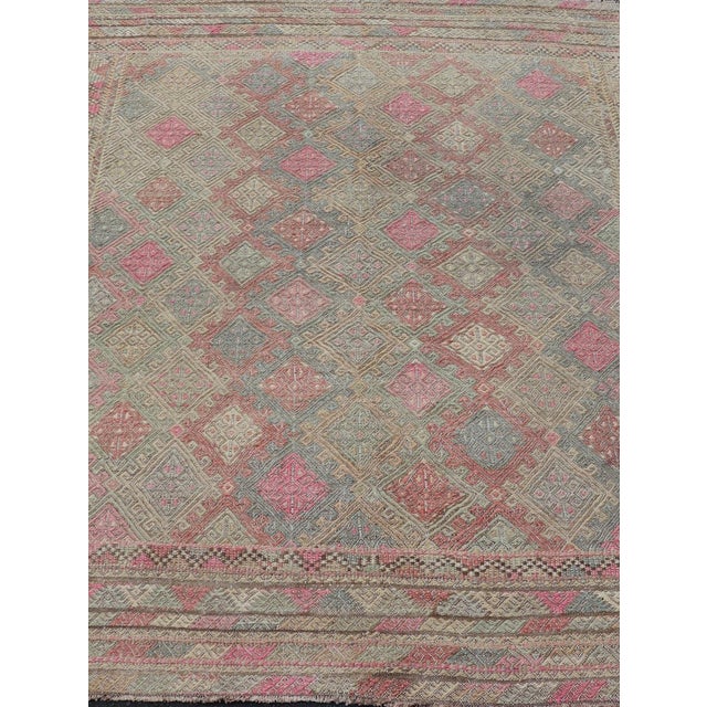 Measures: 5'8 x 7'3 This Turkish Vintage Kilim Rug is a vibrant and intricate example of traditional Anatolian...