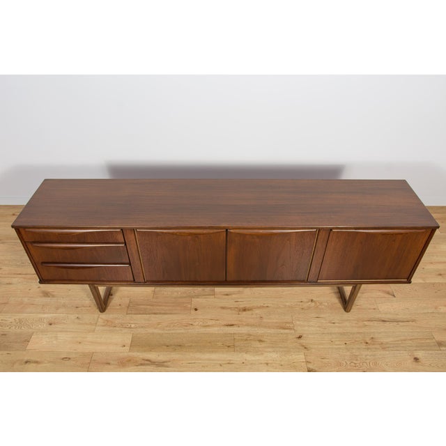 This mid-century sideboard in teak was produced in Great Britain by Stonehill in the 1960s. The sideboard has profiled...