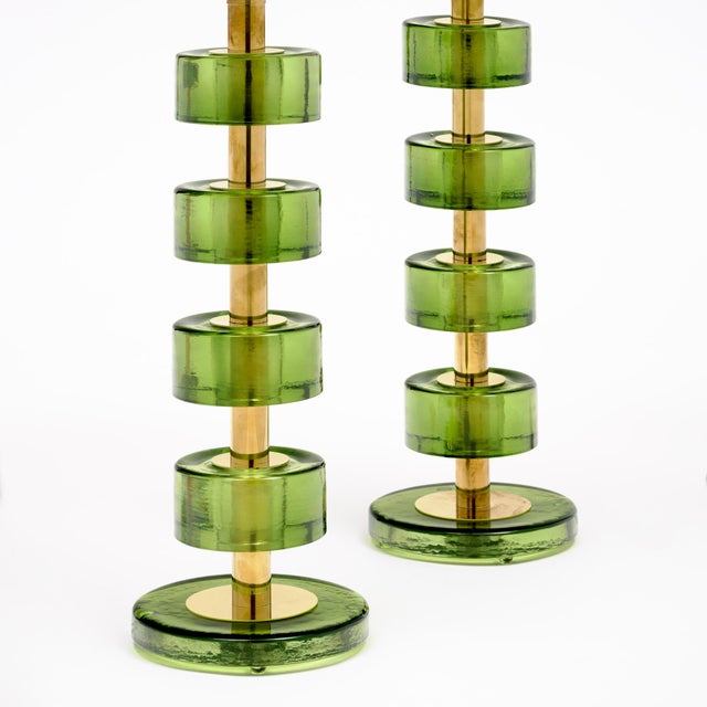 Pair of modern lamps made with brass structures and green hand-blown drum shaped Murano glass components. Each piece has...