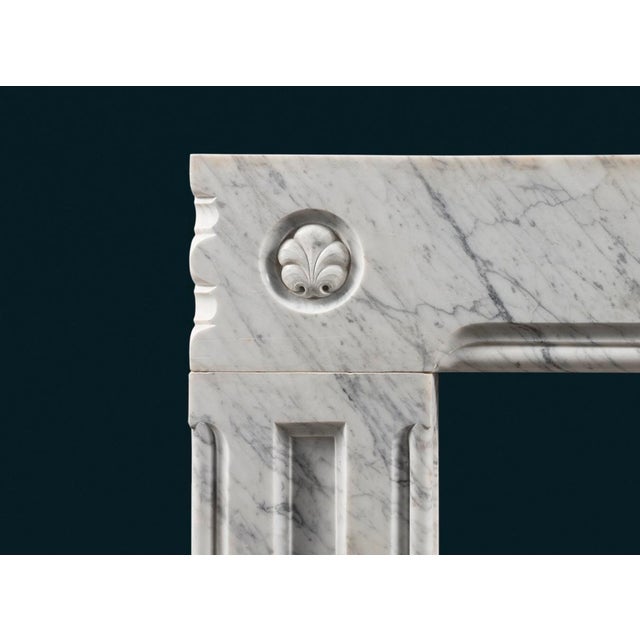 A well carved antique Carrara marble frame fireplace surround with stylised fleur-de-lys set in circular frames to each...