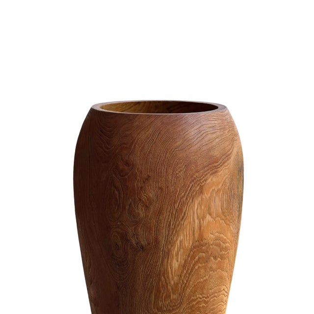 Enhance your decor with this striking teak wood vase, a true testament to natural beauty and craftsmanship. The vase...
