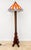 DESCRIPTION: An elegant Amsterdam School floor lamp with a stained glass shade. The shade features a beautiful geometric...