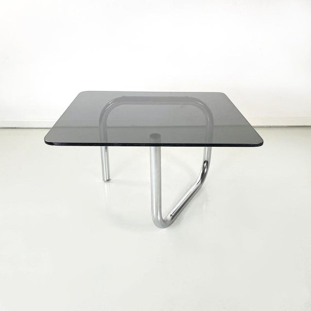 Coffee table with rectangular top and rounded corners in smoked glass. The structure is made up of a single tubular...