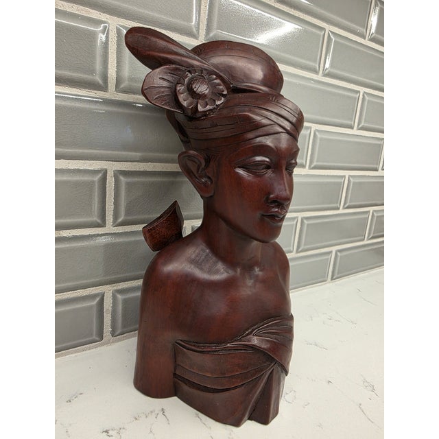 An extraordinary, highly sophisticated mid-century Balinese portrait bust depicting a young nobleman or prince. Standing...
