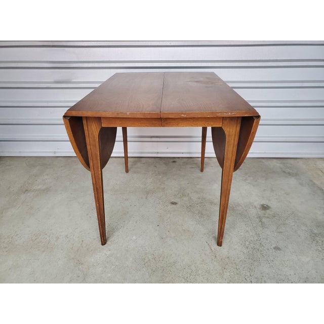 Bring home one of the most iconic Mid Century Modern designs with this vintage Broyhill Brasilia drop leaf dining table....