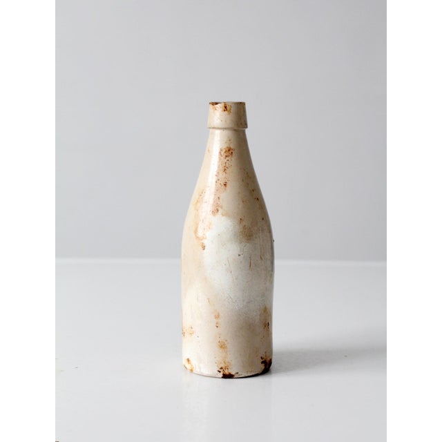 Antique English stoneware bottle by Midland Pottery of Melling, featuring a slender tapered form, creamy off-white glaze,...