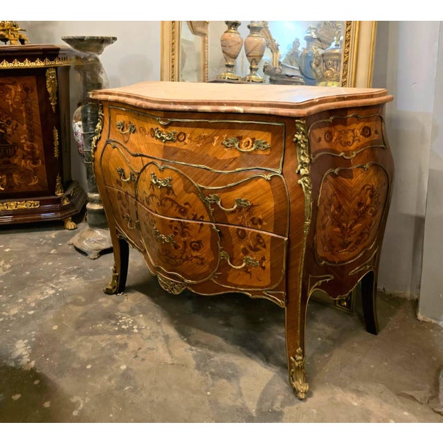 Make a statement with this magnificent French commode, showcasing exceptional floral marquetry, graceful serpentine lines,...