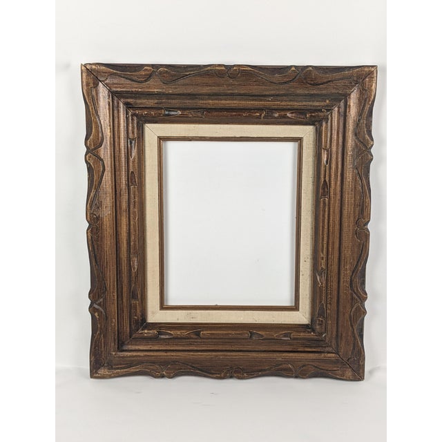 A beautifully detailed vintage carved wood picture frame featuring a substantial, sculptural profile and a rich,...