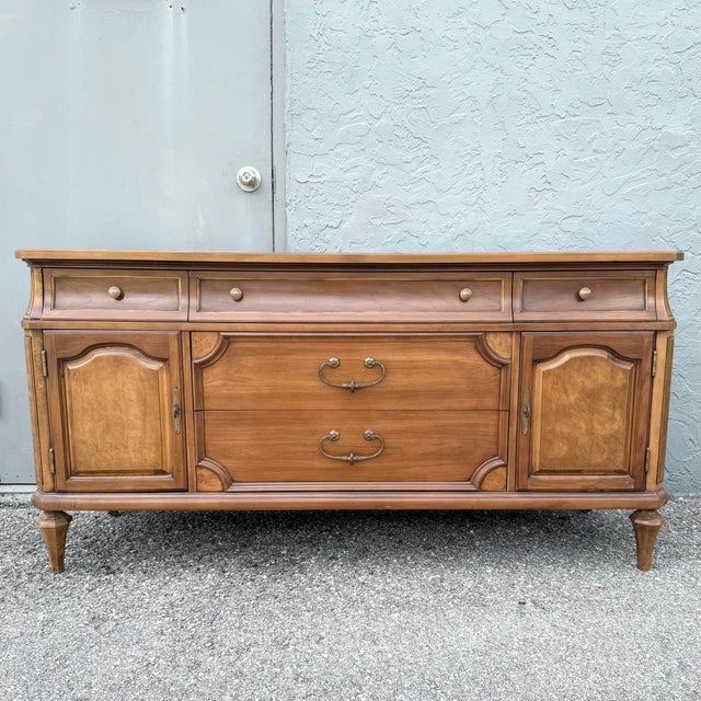 A beautifully crafted vintage Thomasville credenza showcasing timeless Mid-Century Modern design with subtle French-...