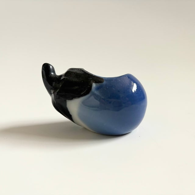 A small vintage ceramic planter in the shape of an eggplant.