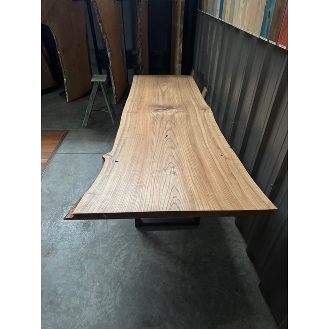A striking, one-of-a-kind table crafted from a single substantial slab of solid elm. Measuring approximately 106 inches...