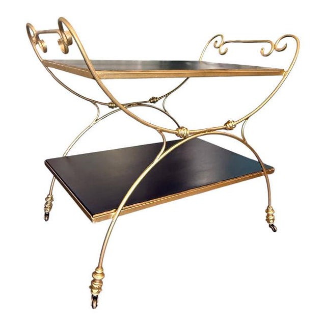 Elegant vintage Hollywood Regency two-tier bar cart featuring a sculptural gilt metal frame with graceful scrolling...
