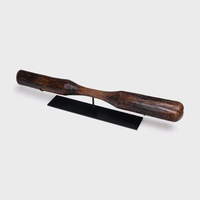 This long wooden object is a 19th-century Chinese pestle, originally used with a large, free-standing mortar to pound rice...