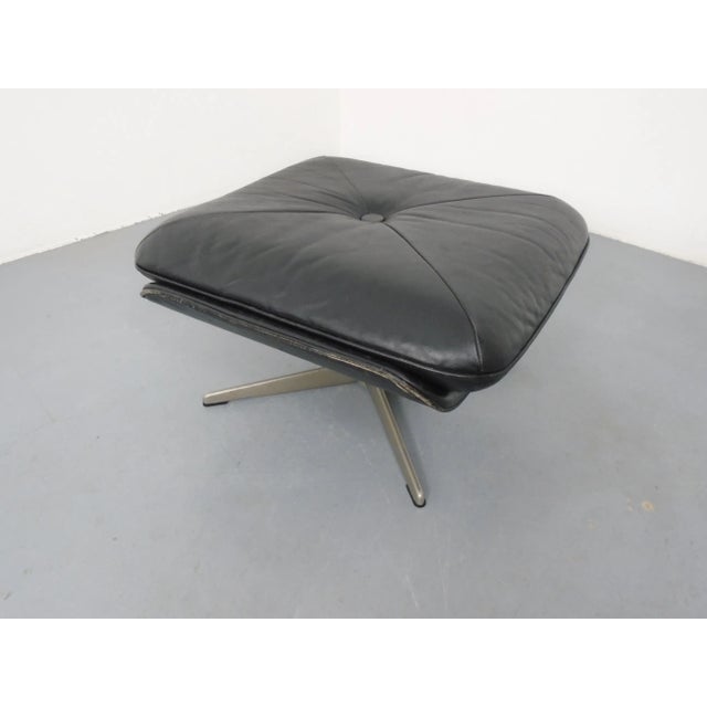Ottoman in black leather with aluminum frame from the 1960s.