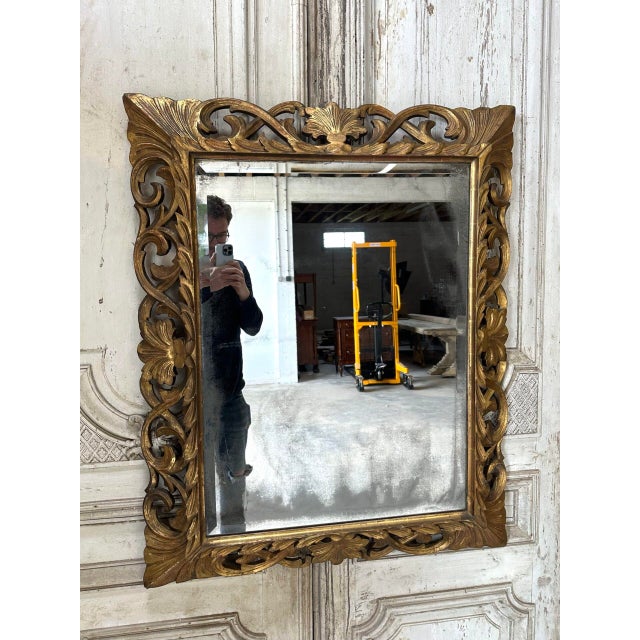 A louis xiv style carved wooden mirror, 19th century. Mercury glass. Original matte gilding. some wear to the silvering of...