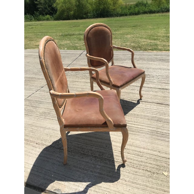 A Pair of Vintage Italian whitewash hand-carved wood armchairs. Original brown suede leather with brass nailhead trim,...