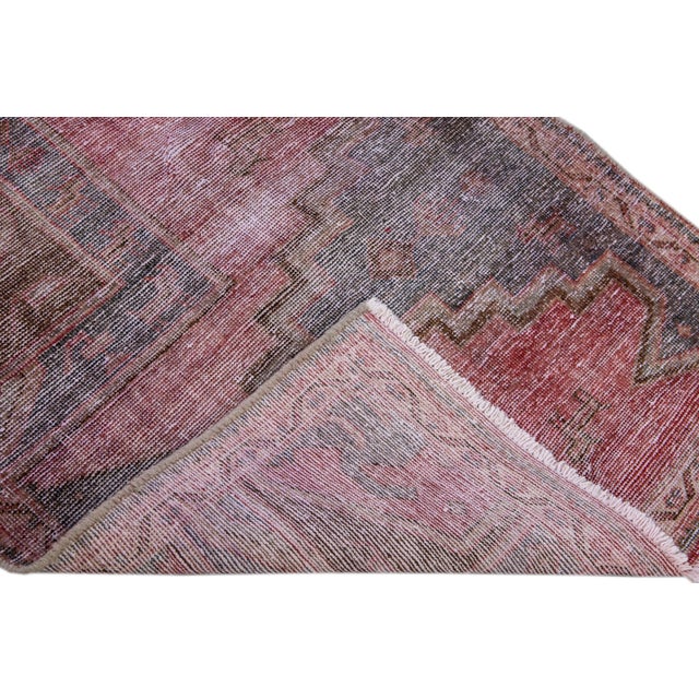 Beautiful Vintage Geometric hand-knotted wool rug with a red field. This rug has blue, purple and brown accents all-over a...