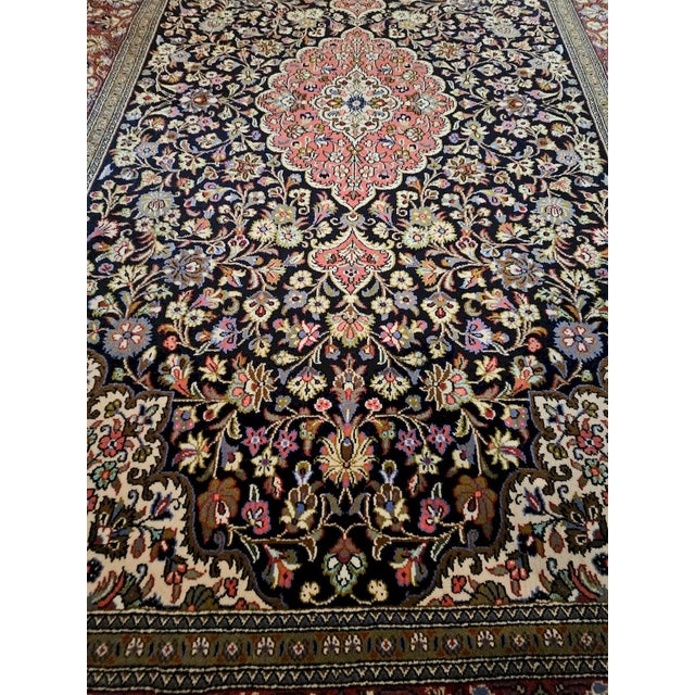 A fine hand-knotted Qum Kurk Super rug, crafted in Iran from superior wool and featuring exquisite craftsmanship. The rug...