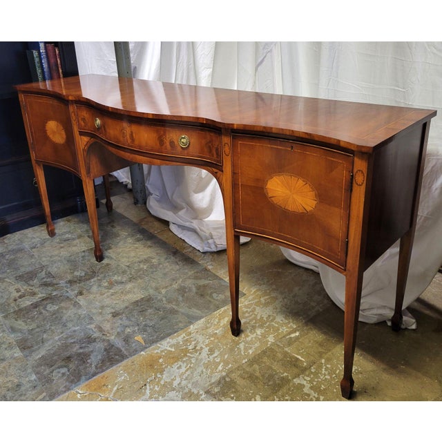 Stunning English burr yew wood sideboard with yew and satin wood inlay. This traditional buffet has a central drawer...