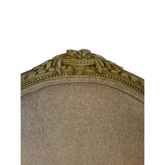 Pair of Louis XVI Bergere chairs newly upholstered in grey flannel fabric. The frames are painted green with carved urn...