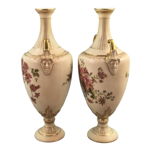 A fine and highly decorative pair of Royal Worcester blush ivory porcelain vases dating to 1900. The vases combine elegant...