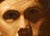 The painting depicts a figure in camouflage attire, gazing directly at the viewer with an intense expression, flanked by...