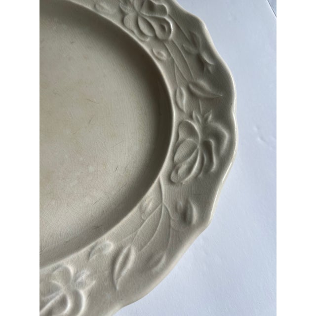 A vintage ironstone platter with decorative leaf detail along the edges. This well loved, crazed piece would be a...