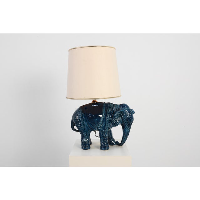A bold and glamorous Hollywood Regency table lamp from Belgium, dating to the 1970s, featuring a striking deep‑blue...