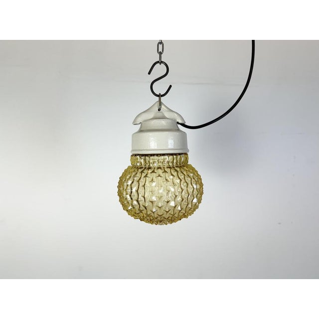 Vintage industrial light made in former Czechoslovakia during the 1970s. It features a white porcelain top and a glass...