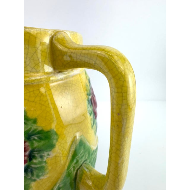 Vintage Japanese majolica-style pitcher featuring raised strawberry and leaf motifs in a vibrant yellow glaze, set above a...